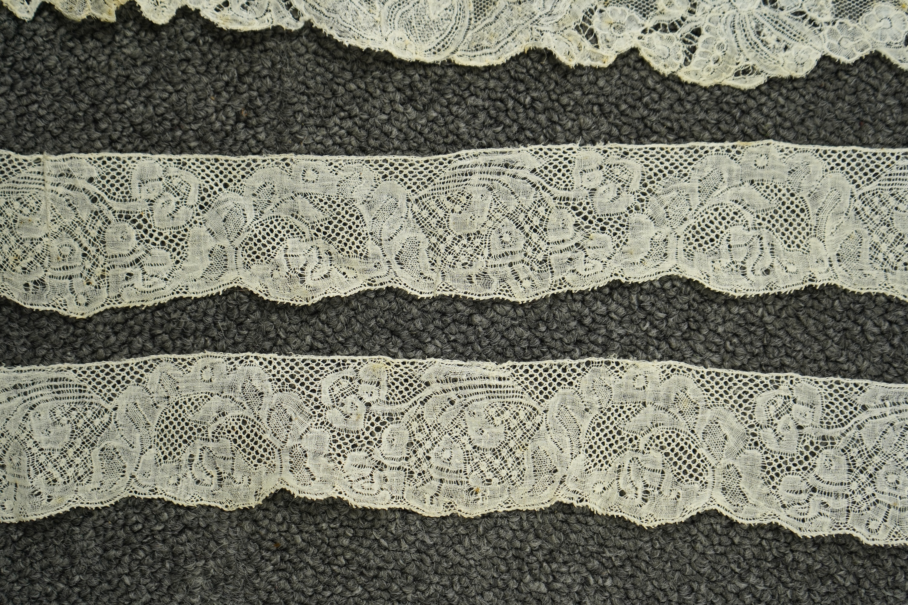 Various lengths of 18th and 19th century lace trimming and two needle run bonnets. Including a collar made from two rows of 18th century Valenciennes lace, a length Valenciennes lace, a shorter length of Pointe de Anglet